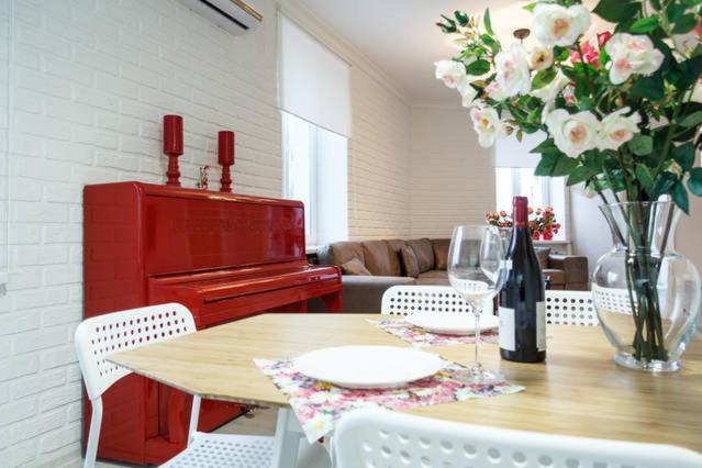 uma sala de jantar com uma mesa com um piano vermelho em Lotos for You Apartments 2, RED PIANO em Nikolayev
