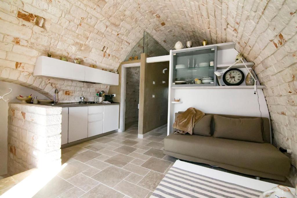 a kitchen and living room with a couch in a room at Dimora Lumi in Locorotondo