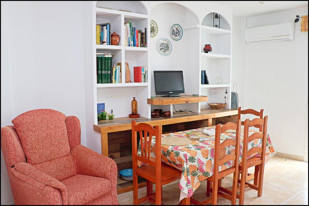 Habitación con escritorio, ordenador y silla. en Apartamento Sol II, en Conil de la Frontera