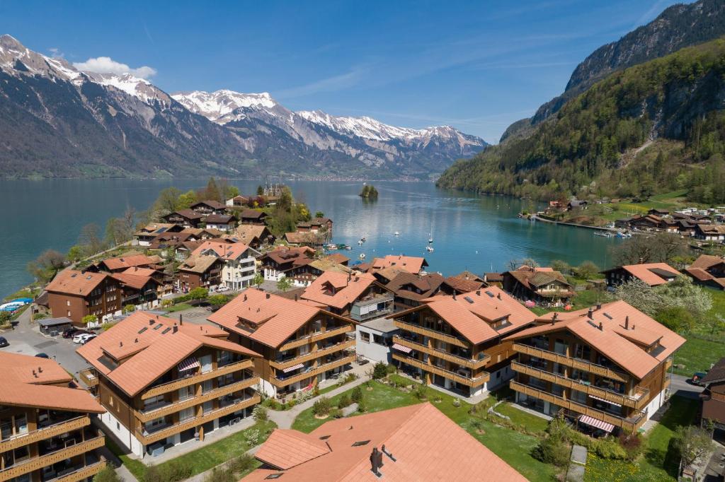an aerial view of a village on a lake with mountains at Chalet Apartments Iseltwald in Iseltwald