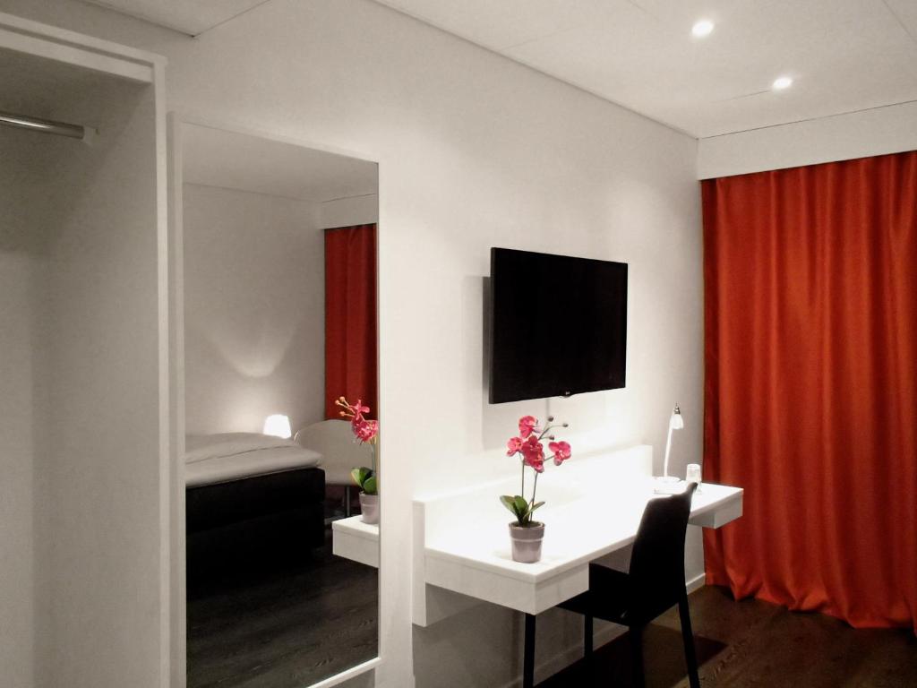 a room with a desk and a red curtain at Forenom Aparthotel Gothenburg Nolvik in Säve