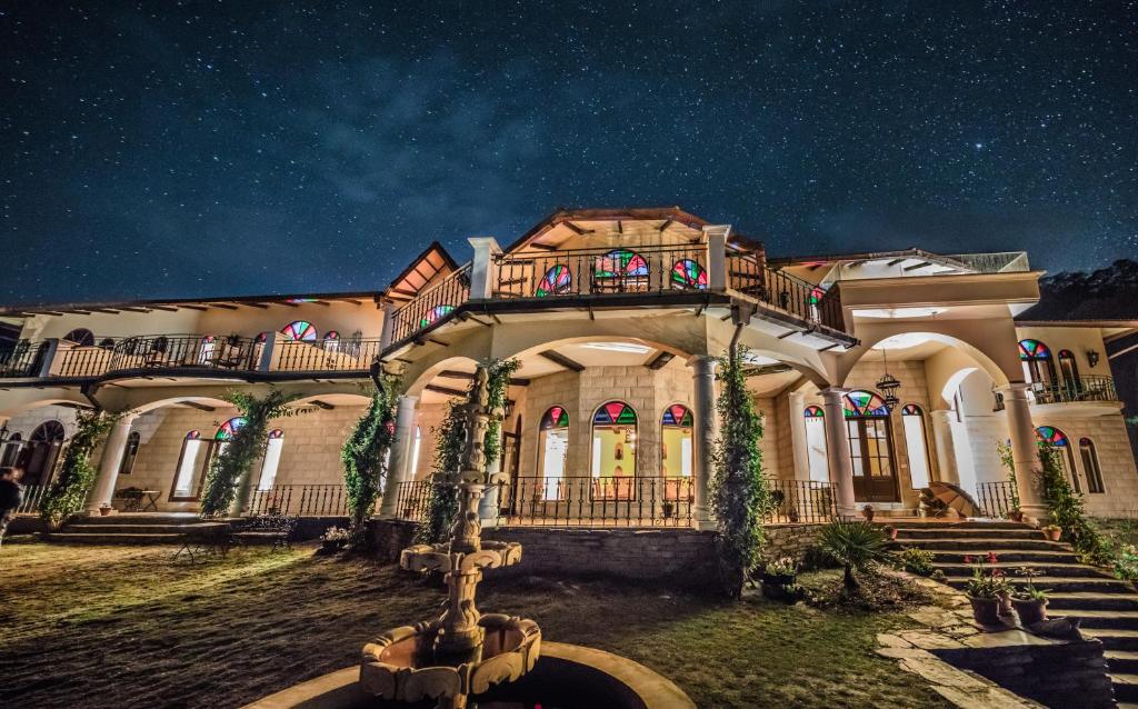 a large house with a fountain in front of it at The Orchard at Peora Estates in Mukteshwar