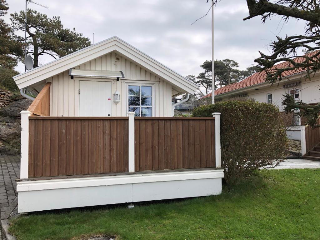 une clôture en bois devant une maison dans l'établissement Lillstugan, à Kärradal