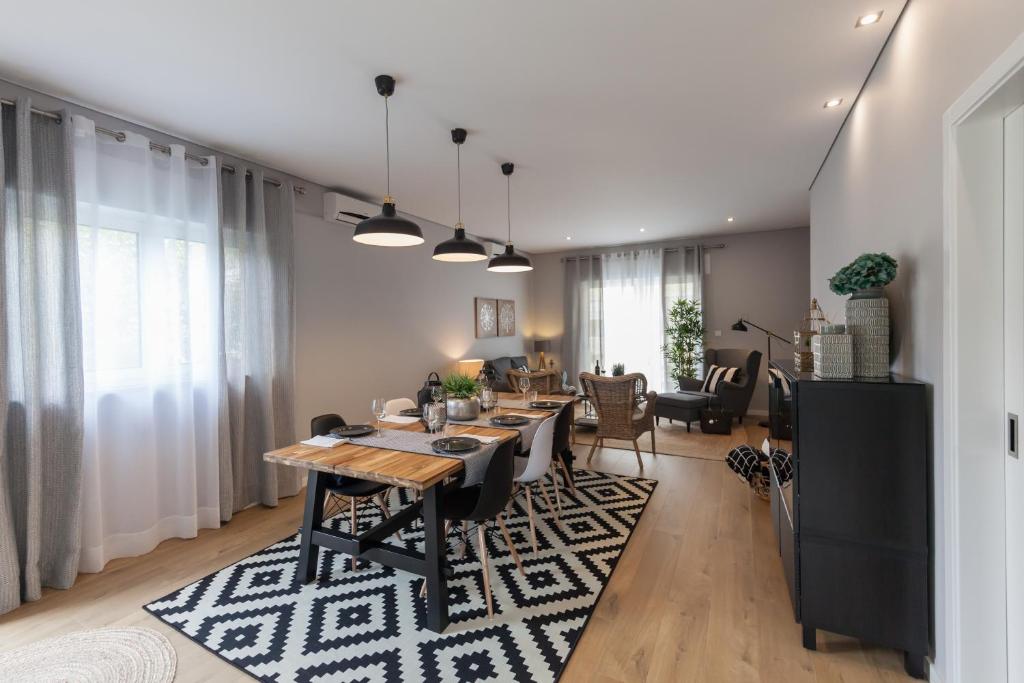 a dining room and living room with a table and chairs at Quinta da Salada - Alojamento Local Douro in Peso da Régua