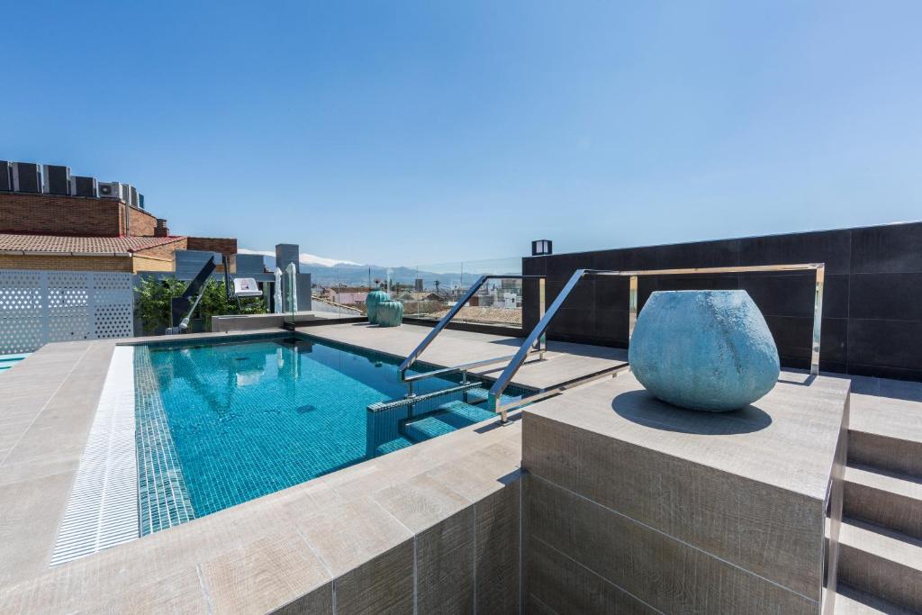 une piscine sur le toit d'un bâtiment dans l'établissement Catalonia Granada, à Grenade