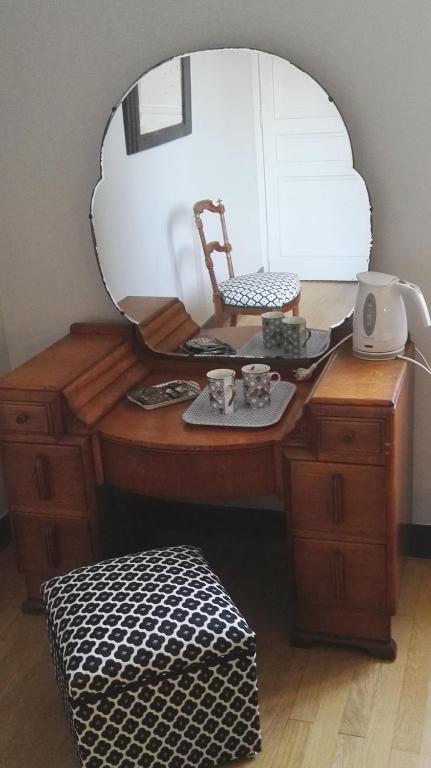 a dressing table with a mirror and a chair on it at Résidence de Vaux in Nans-sous-Sainte-Anne