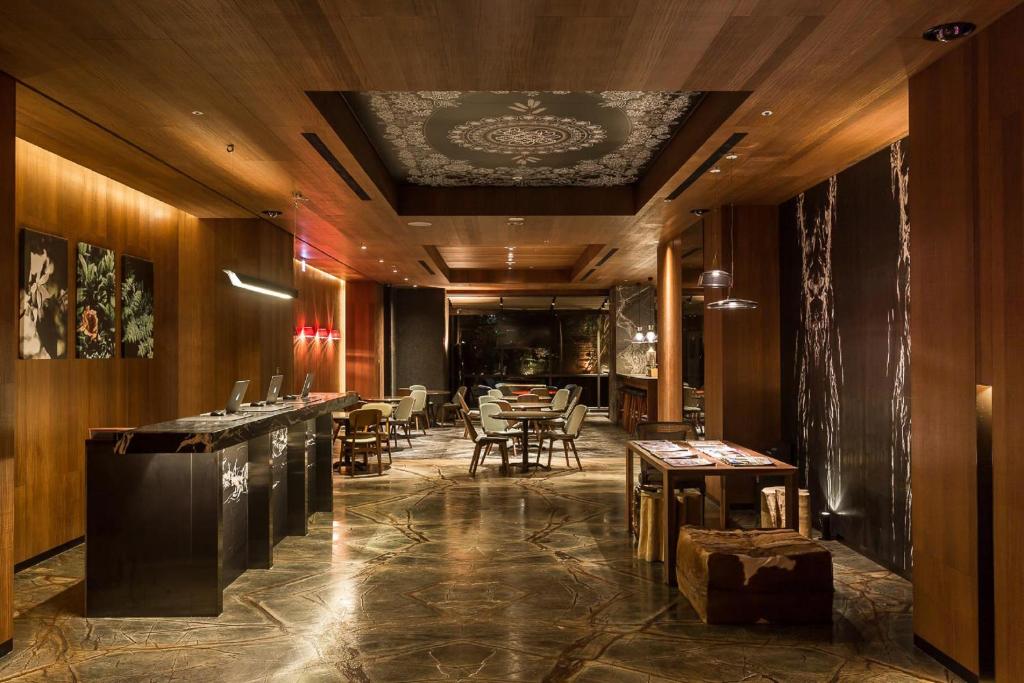 un restaurante con un bar con mesas y sillas en Inhouse Hotel Taichung en Taichung