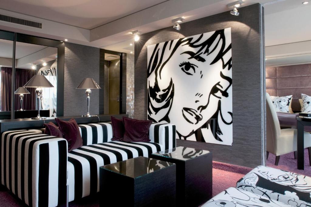 a living room with a couch and a painting of a woman at Atrium Hotel Mainz in Mainz