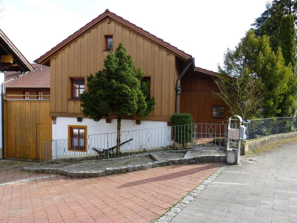 ein großes Holzhaus mit einem Baum davor in der Unterkunft Ferienwohnung Baier in Bad Griesbach