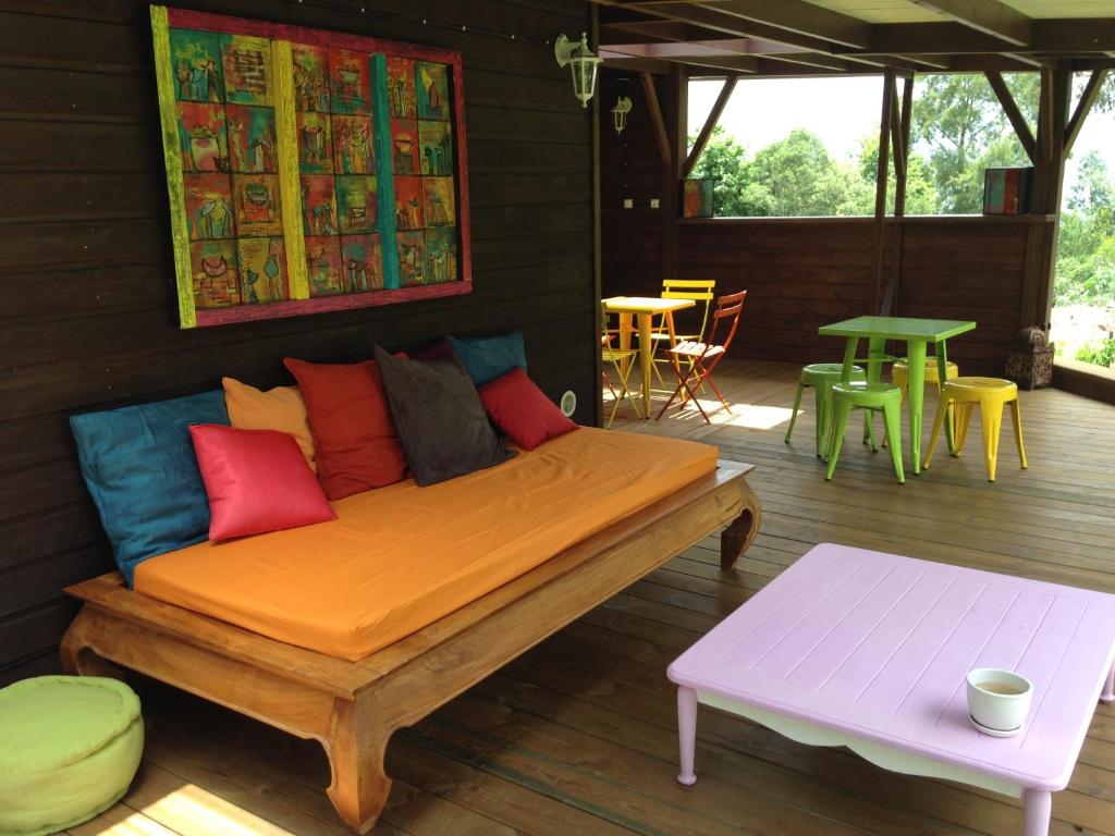 a wooden bed with colorful pillows on a patio at belle la vie in La Plaine des Cafres