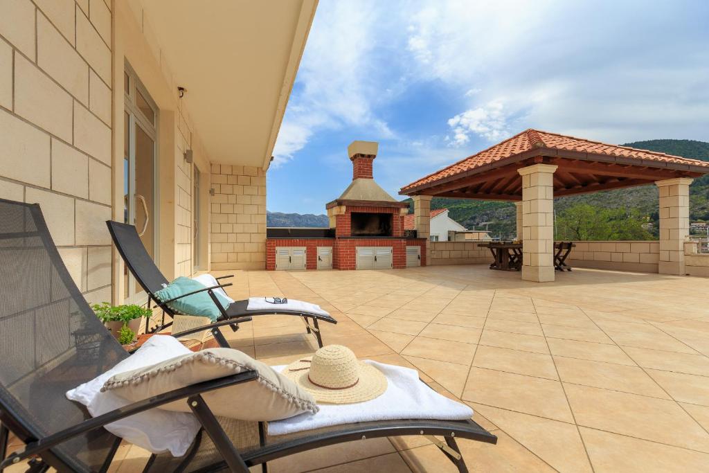 a patio with a rocking chair and a gazebo at Apartments Mondo in Mokošica