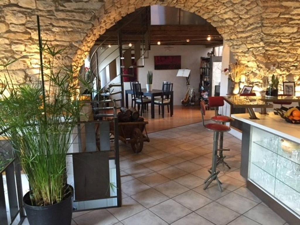 Habitación con pared de piedra, mesa y sillas. en Le Paillier d'Etienne., en La Cresse