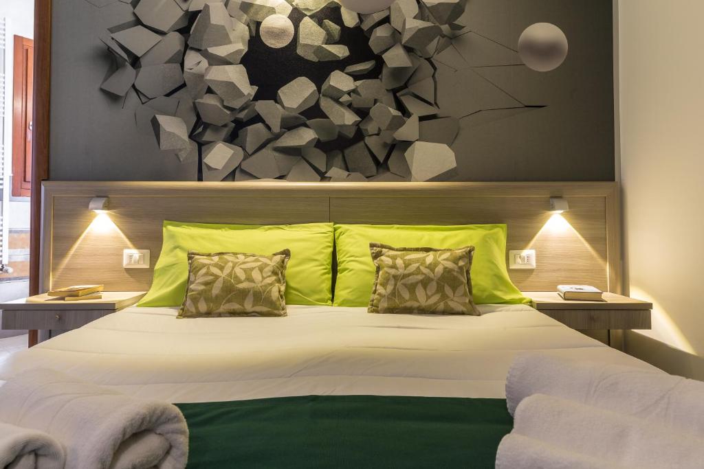 a bedroom with a large bed with green pillows at La Piazzetta Guest House in Olbia