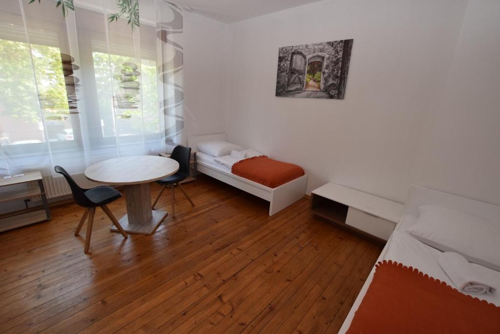 a room with a table and a bed and a desk at Apartment Ostendplatz in Stuttgart