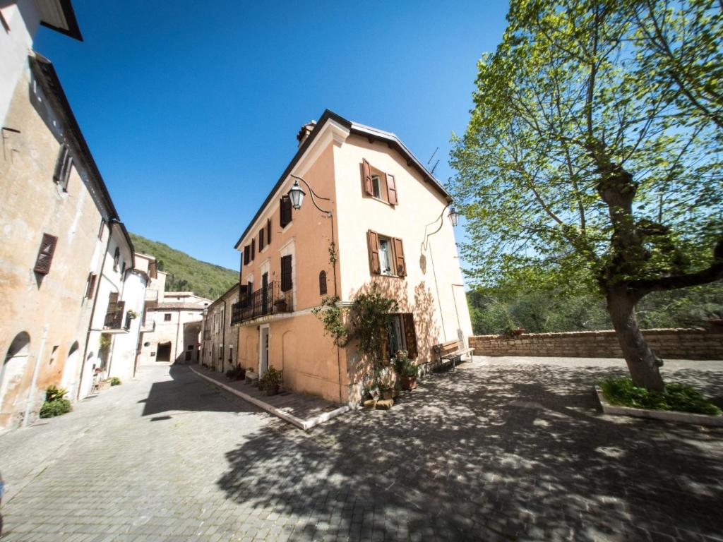 an empty street with a building and a tree at Casa Di Mamma Casa Vacanze in Genga