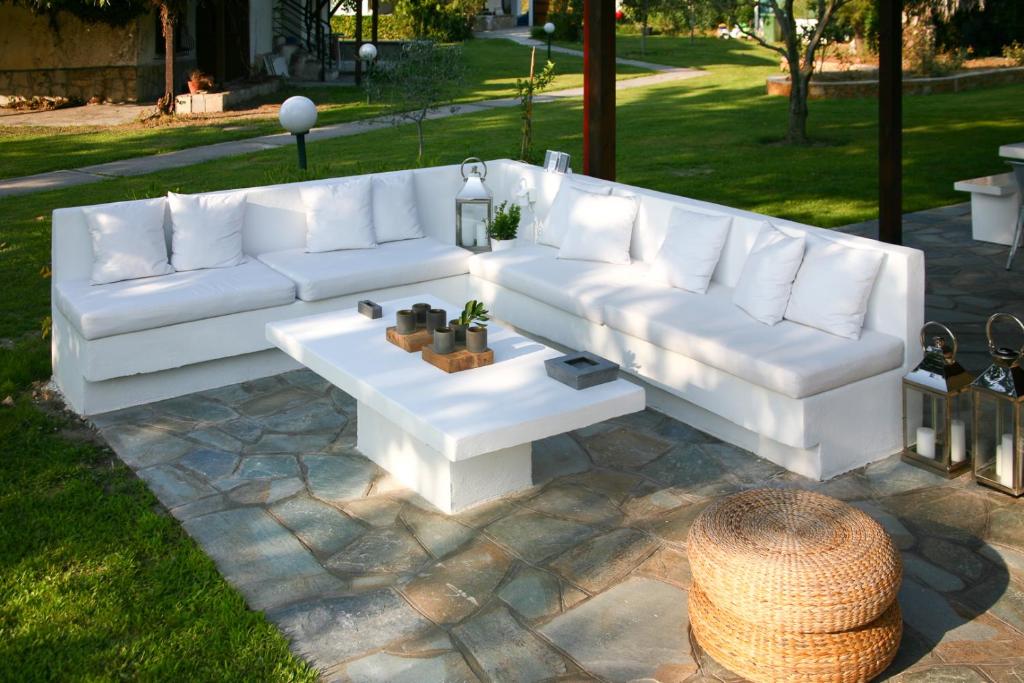 a white couch sitting on top of a patio at #Luxlikehome - The Seascape Villa in Skála Foúrkas