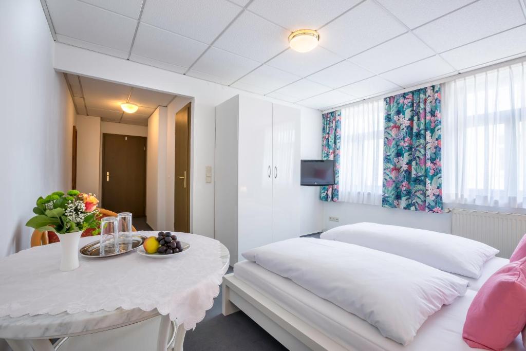 a hotel room with a bed and a table with a plate of fruit at Hotel Annet garni in Meerane