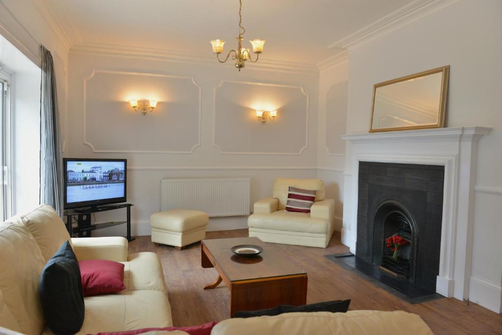 a living room with a couch and a fireplace at Clarendon House in Shanklin