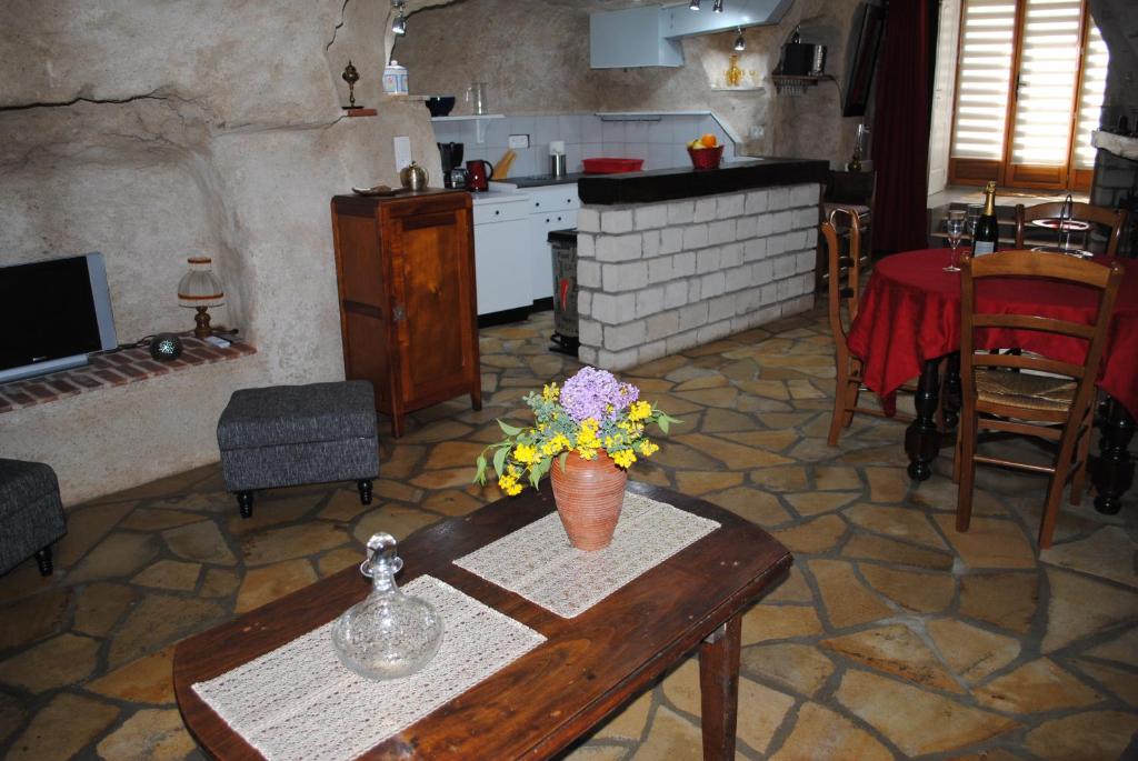 een woonkamer met een tafel met bloemen erop bij Gite " Le Troglo des 3 Châteaux " in Amboise