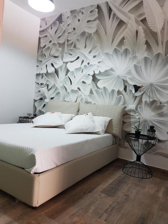 a bedroom with a bed with a floral wall mural at Appartamento urban in Custonaci