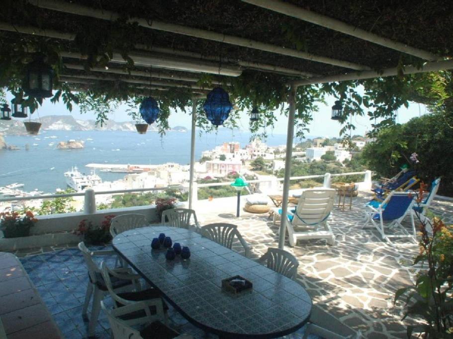 una mesa y sillas en un patio con vistas al océano en Villa Glicine, en Ponza