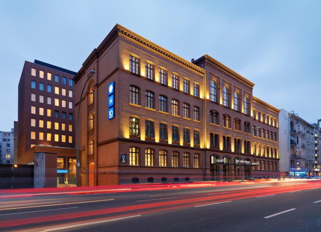 a large brick building on a city street at night at H10 Berlin Ku'damm in Berlin