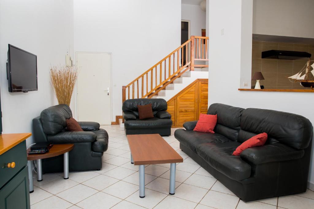 uma sala de estar com dois sofás de couro e uma mesa em Atlantis Home em Antananarivo