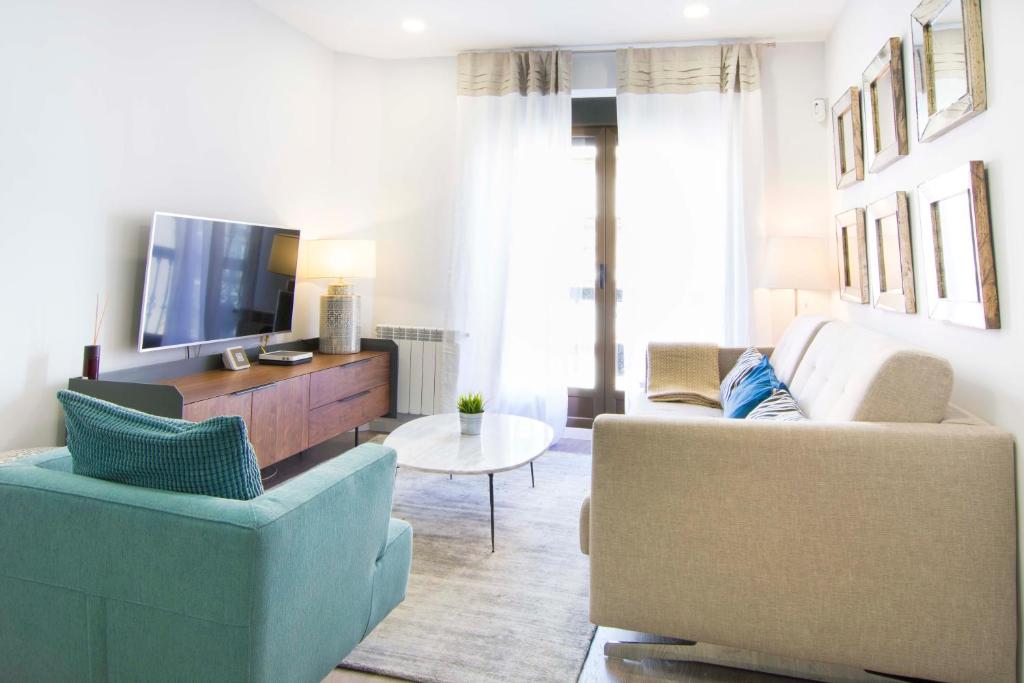 a living room with two chairs and a tv at Apartment Alcala 146 in Madrid