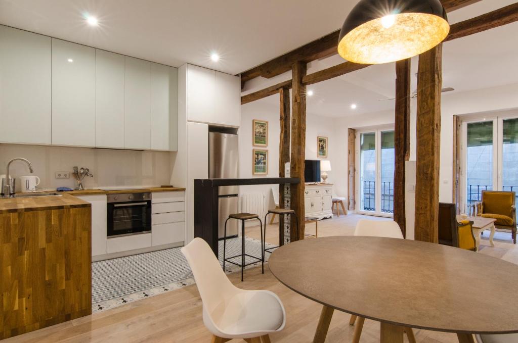 uma cozinha e sala de estar com mesa e cadeiras em Apartment Fomento em Madrid