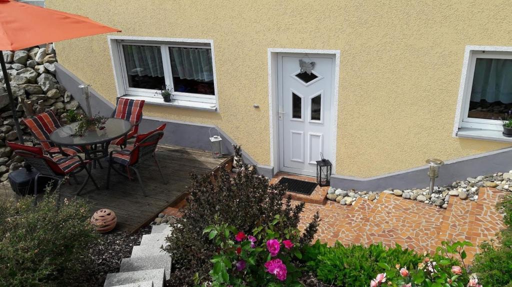 a patio with a table and chairs next to a house at Ferienwohnung Rockmann in Kirchenlamitz
