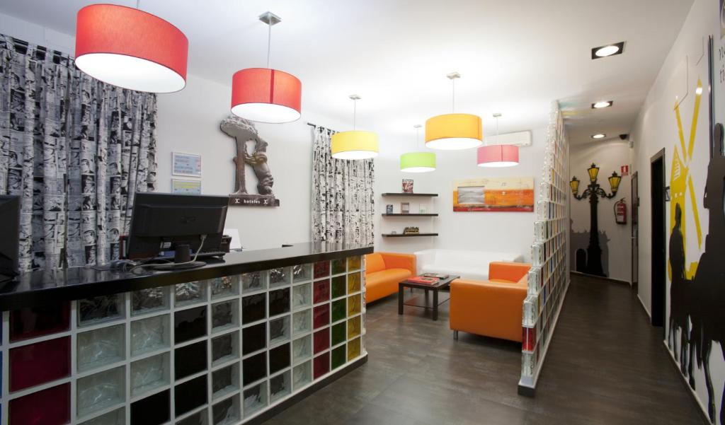 a waiting room with an orange couch and pendant lights at JC Rooms Santa Ana in Madrid