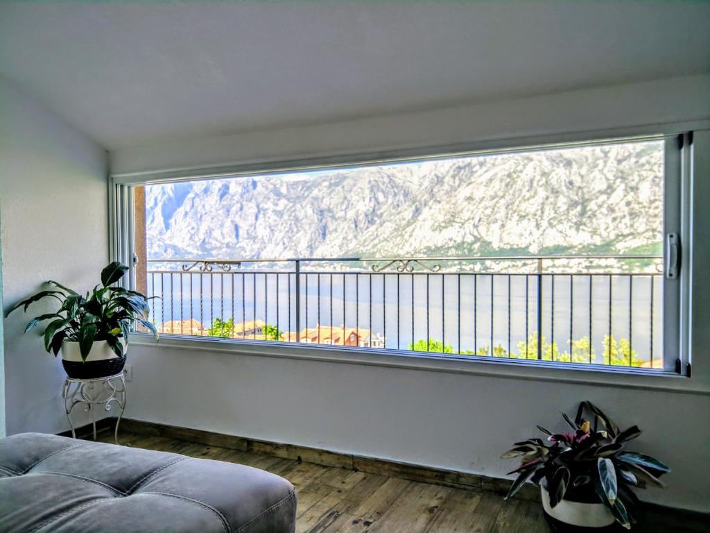 uma sala de estar com uma grande janela com vista para a montanha em Lux Apartments Fabris em Kotor