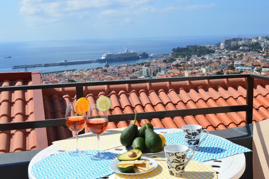 - une table avec des fruits et des verres à vin sur le balcon dans l'établissement House in Funchal with panoramic view 2-6, à Funchal