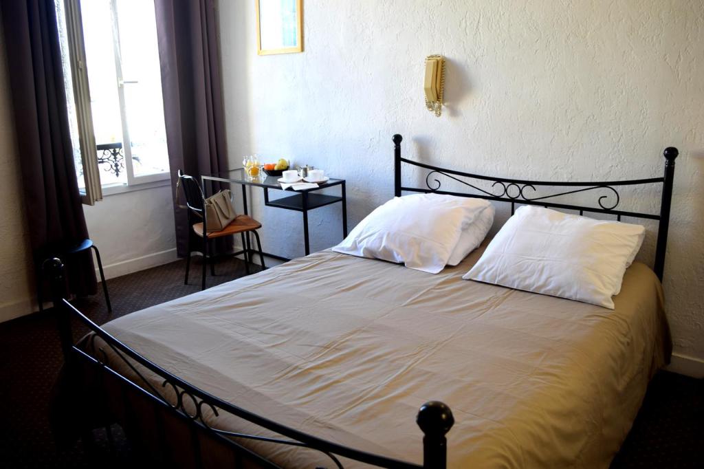 Postel nebo postele na pokoji v ubytování Nouvel Hotel