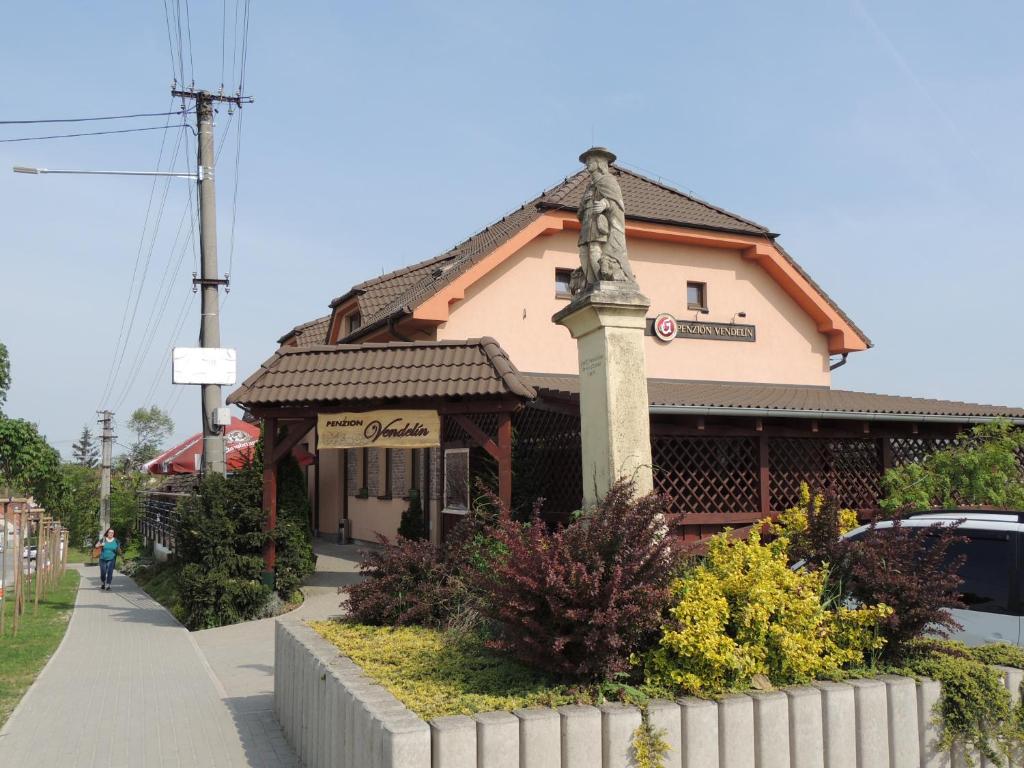 a building with a cross on the front of it at Penzión Vendelín in Veľké Zálužie