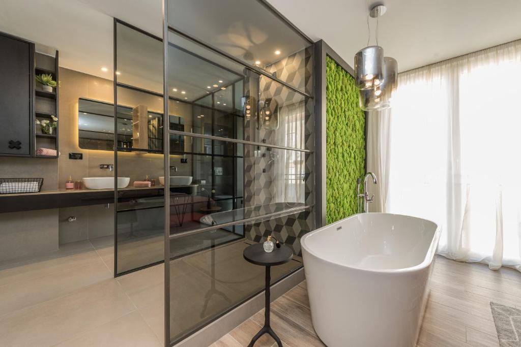 Apartments & Rooms Mareta Exclusive في زادار: حمام مع حوض كبير ومغسلة