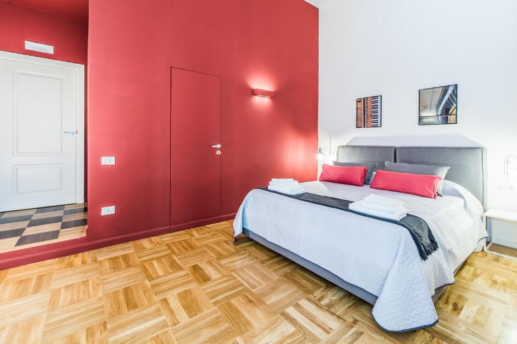ナポリにあるDama Suiteの赤い壁とウッドフロアのベッドルーム1室