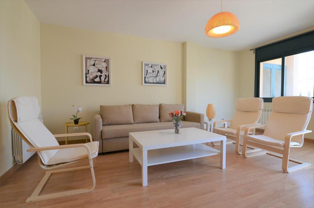 een woonkamer met een bank, stoelen en een tafel bij Apartamentos Elcano in Cambrils
