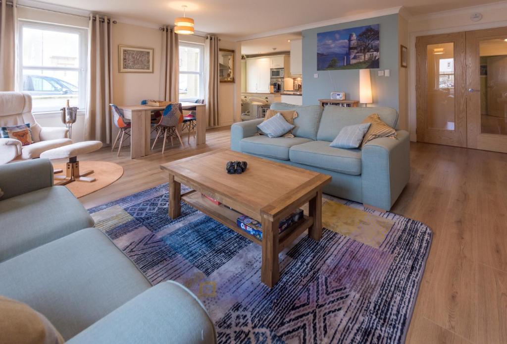 a living room with blue couches and a coffee table at Marina View Apartment in Inverkip