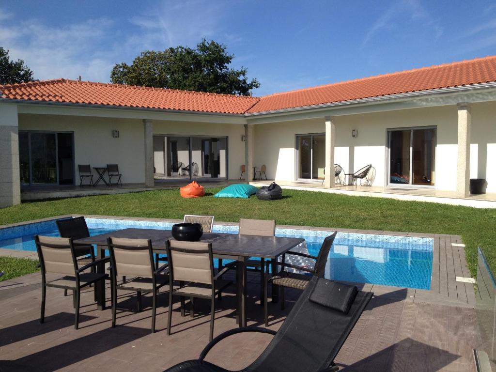 eine Terrasse mit einem Tisch und Stühlen neben einem Pool in der Unterkunft Villa Piscine Portugal in Coucieiro