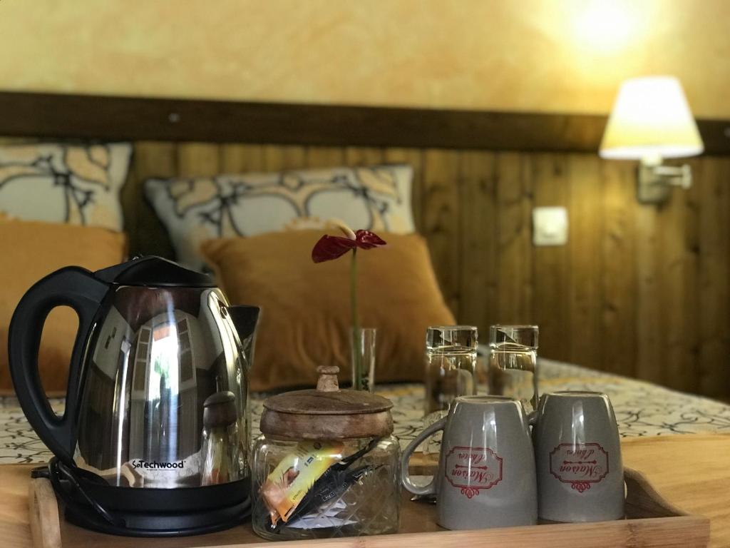 a tea kettle and two cups on a table at Auberge Desprairies in Saint-Joseph