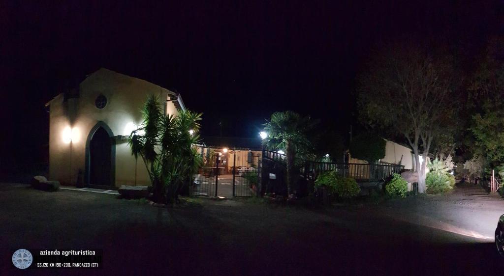 une église la nuit avec une clôture et des arbres dans l'établissement Agriturismo Borgo San Nicolao, à Randazzo