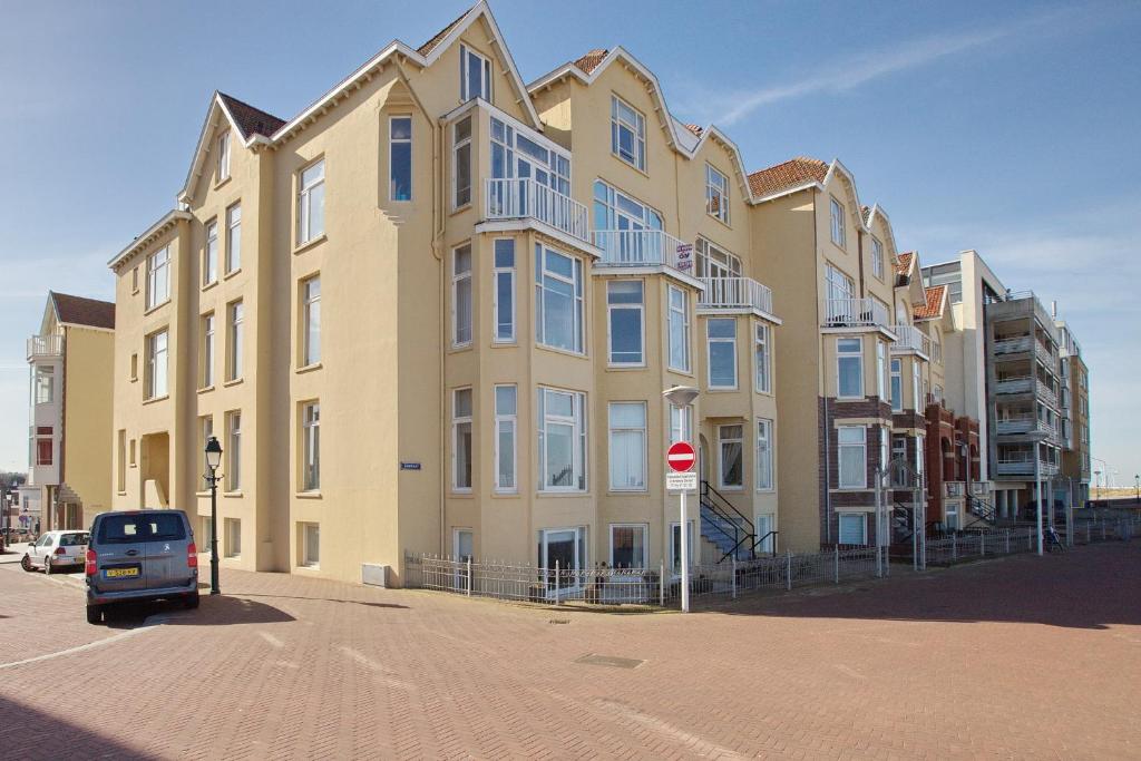 un gran edificio con un coche aparcado delante de él en Studio 45D en Scheveningen