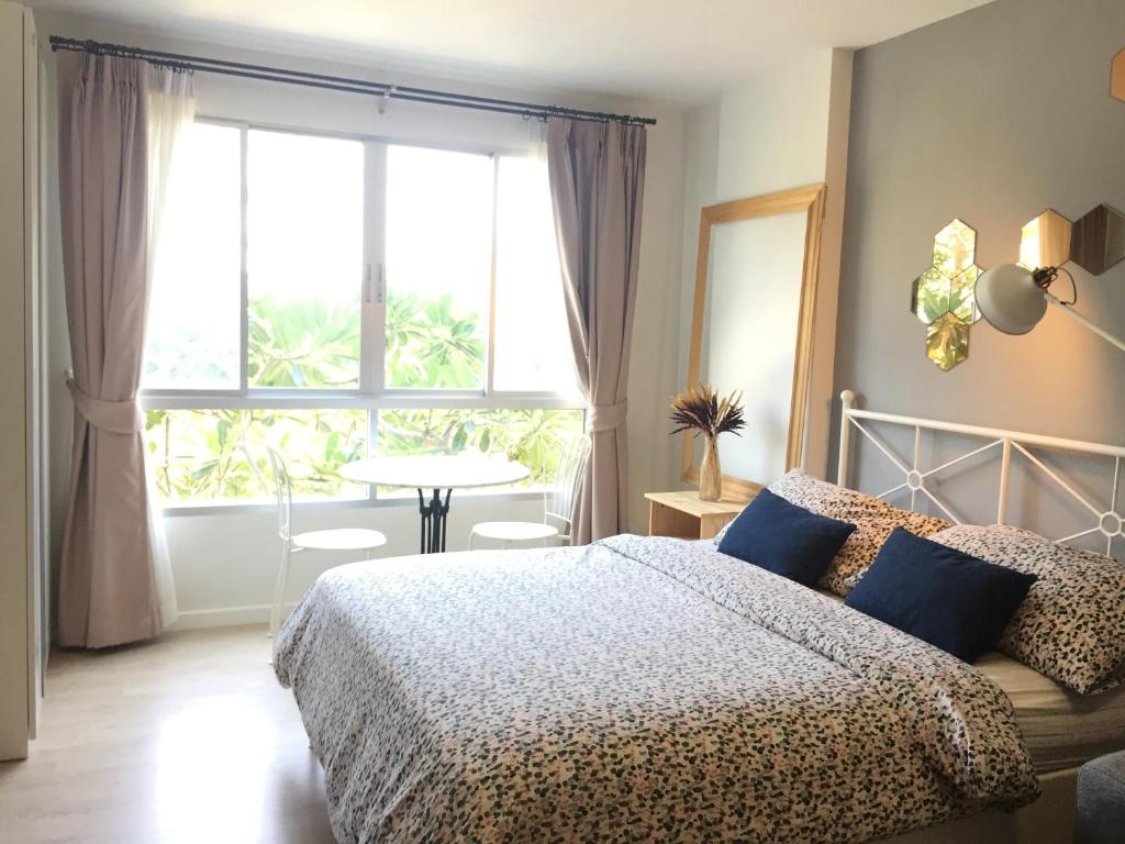 a bedroom with a bed and a large window at Baan Peang Ploen by Pattama in Hua Hin
