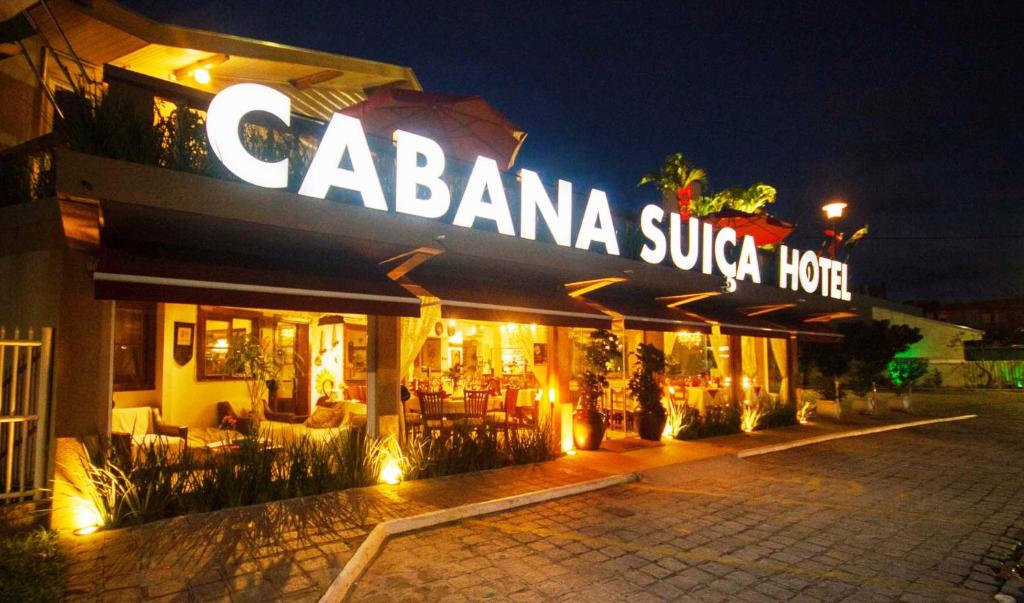um restaurante com uma placa que lê cabaania sukrita hotel à noite em Hotel Cabana Suiça em Guaratuba