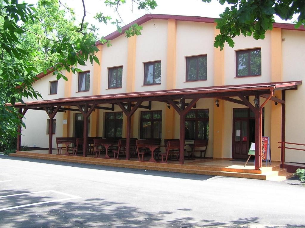 a building with tables and chairs in front of it at Árnyas Thermal Camping és Üdülőpark in Püspökladány