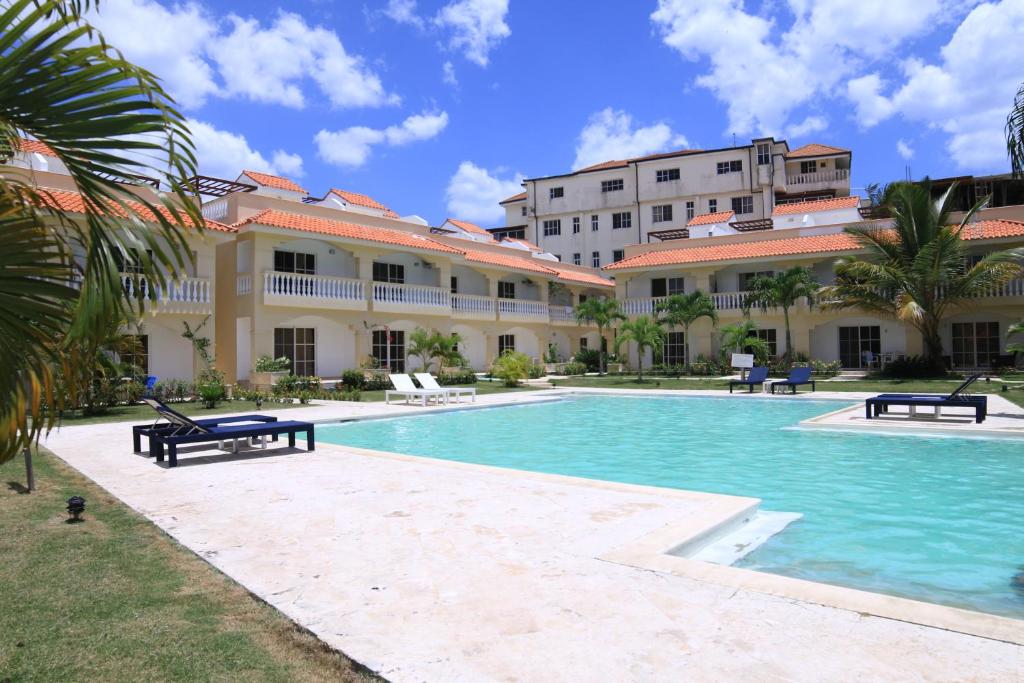 a swimming pool in front of a building at Residencial Las Estrellas in Boca Chica