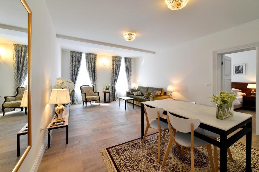 a dining room and living room with a table and chairs at Manduša Heritage Apartments in Zagreb