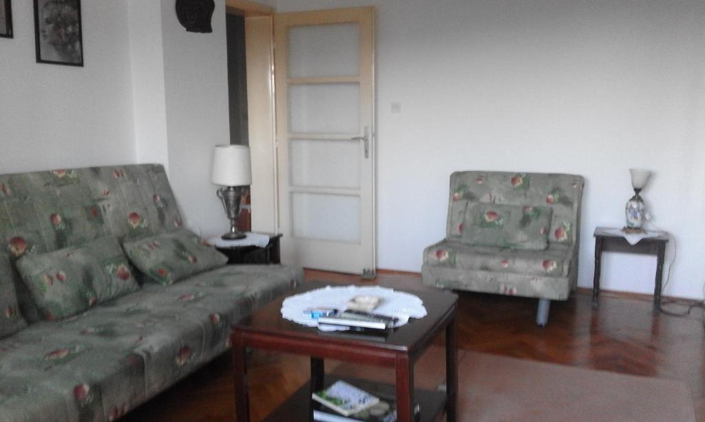 a living room with a couch and a table and two chairs at Apartman na Savini in Herceg-Novi