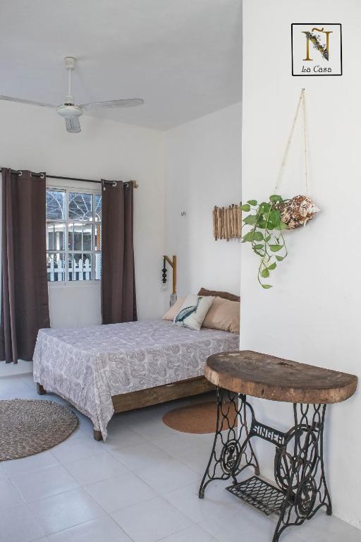 a bedroom with a bed and a table at La Casa de Ñaña in Holbox Island